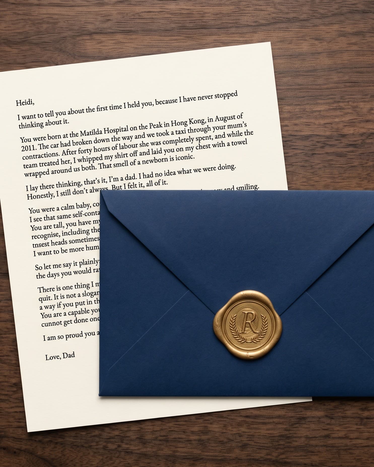 A Tribute Letter on cream paper beneath a navy envelope sealed with gold wax, on a walnut table